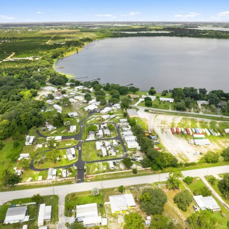 A wide-angle view of Lake Letta RV Park in Avon Park, FL, showcasing the homes and beautifully landscaped surroundings in the 55+ community.