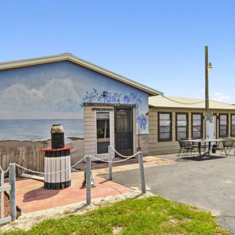 The exterior of a tropical-style clubhouse where seniors can enjoy activities and events at Lake Letta RV Park in Avon Park, FL.