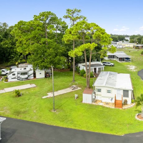 A well-maintained RV site with paved roads, hookups, and shaded spots, showcasing the premium RV accommodations available at Lake Letta RV Park in Avon Park, FL.