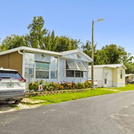 The exterior of a tropical-style clubhouse where seniors can enjoy activities and events at Lake Letta RV Park in Avon Park, FL.