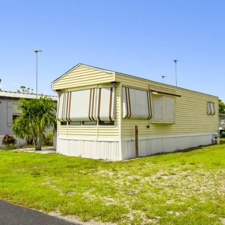 The exterior of a tropical-style clubhouse where seniors can enjoy activities and events at Lake Letta RV Park in Avon Park, FL.